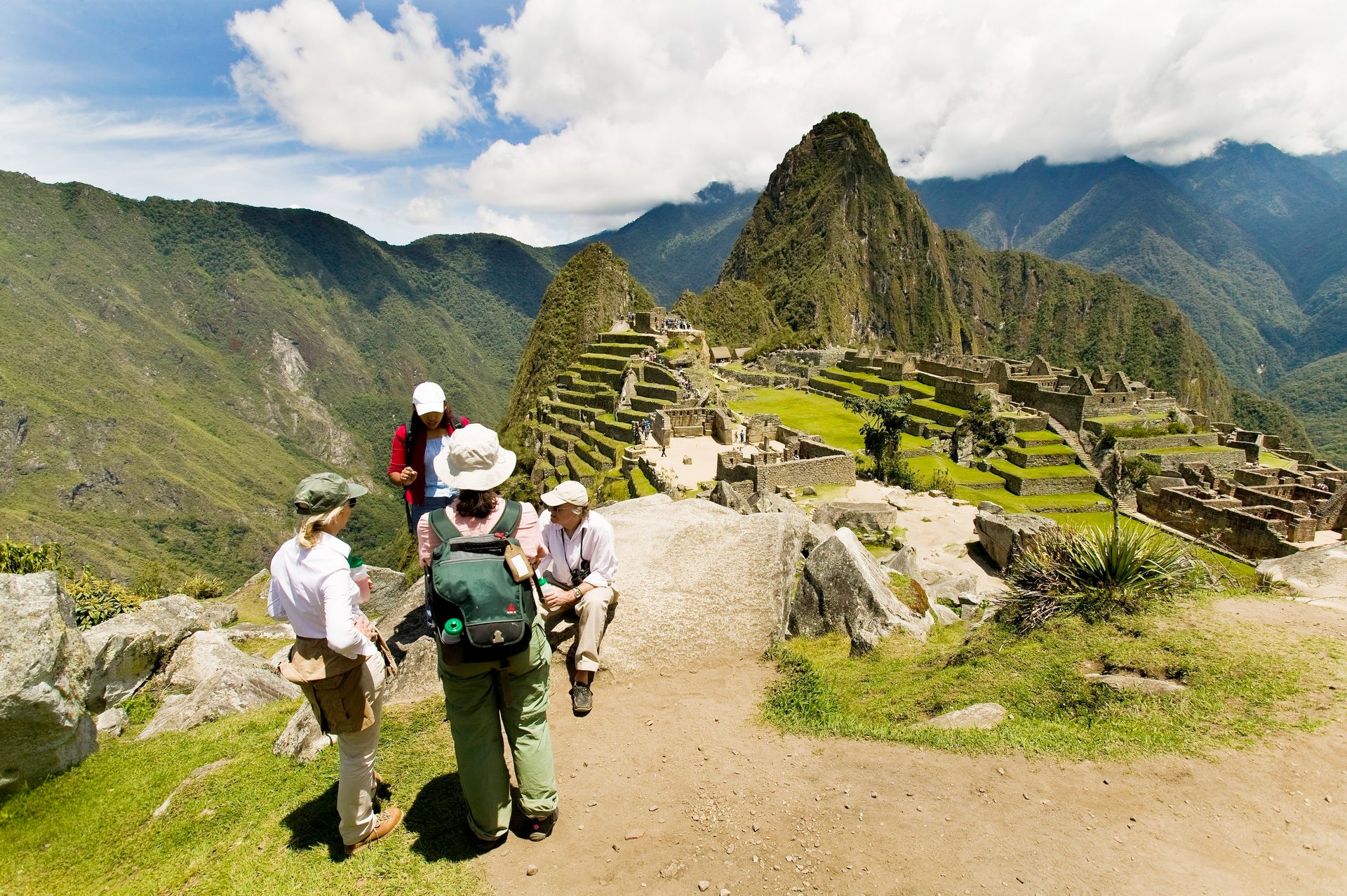 A group of people overlooking the ancient Inca city of Machu Picchu with mountains in the background.