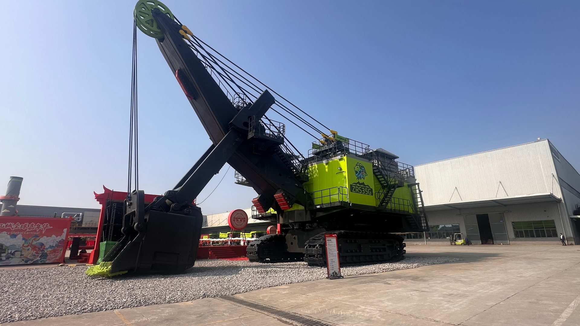 Massive green and black ZRS35G shovel excavator on display outdoors.