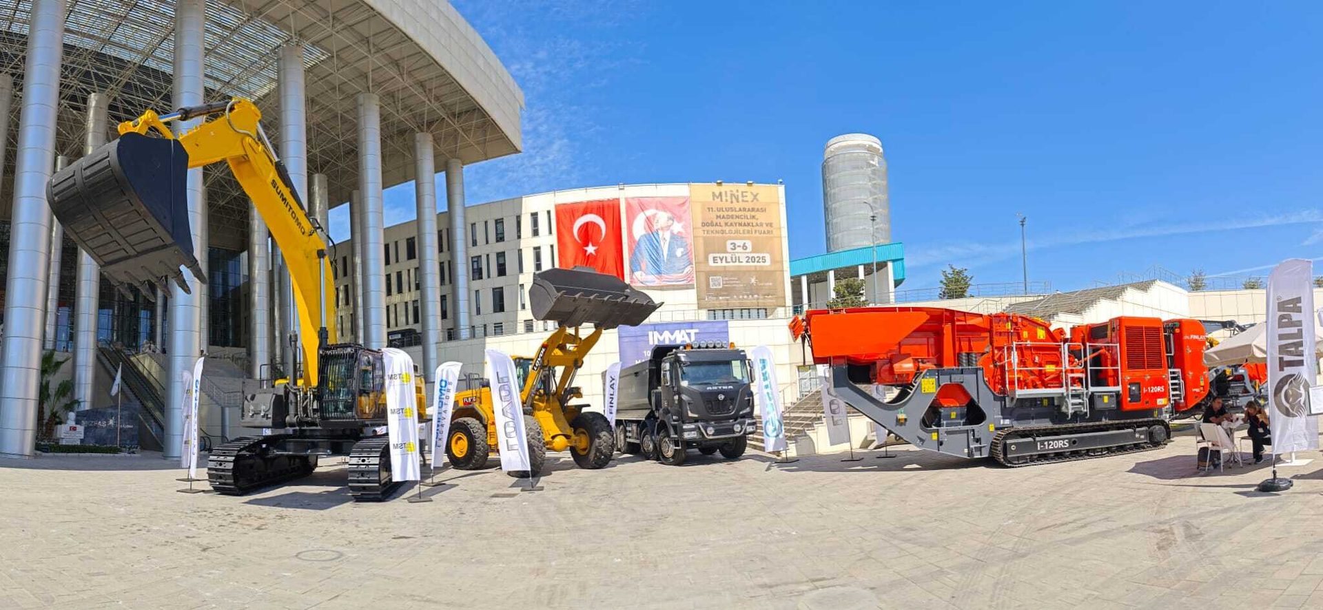 Mining machinery (excavator, loader, truck, crusher) on display at Minex 2025 exhibition.
