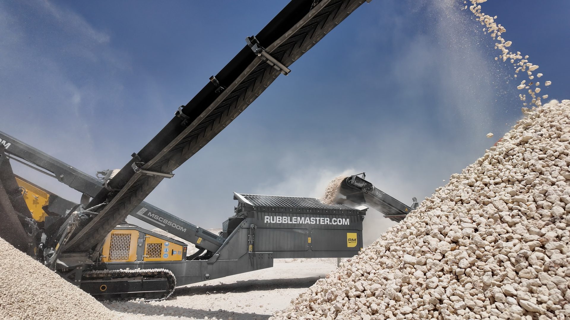 Rubble Master machinery crushing white rocks into a large pile.