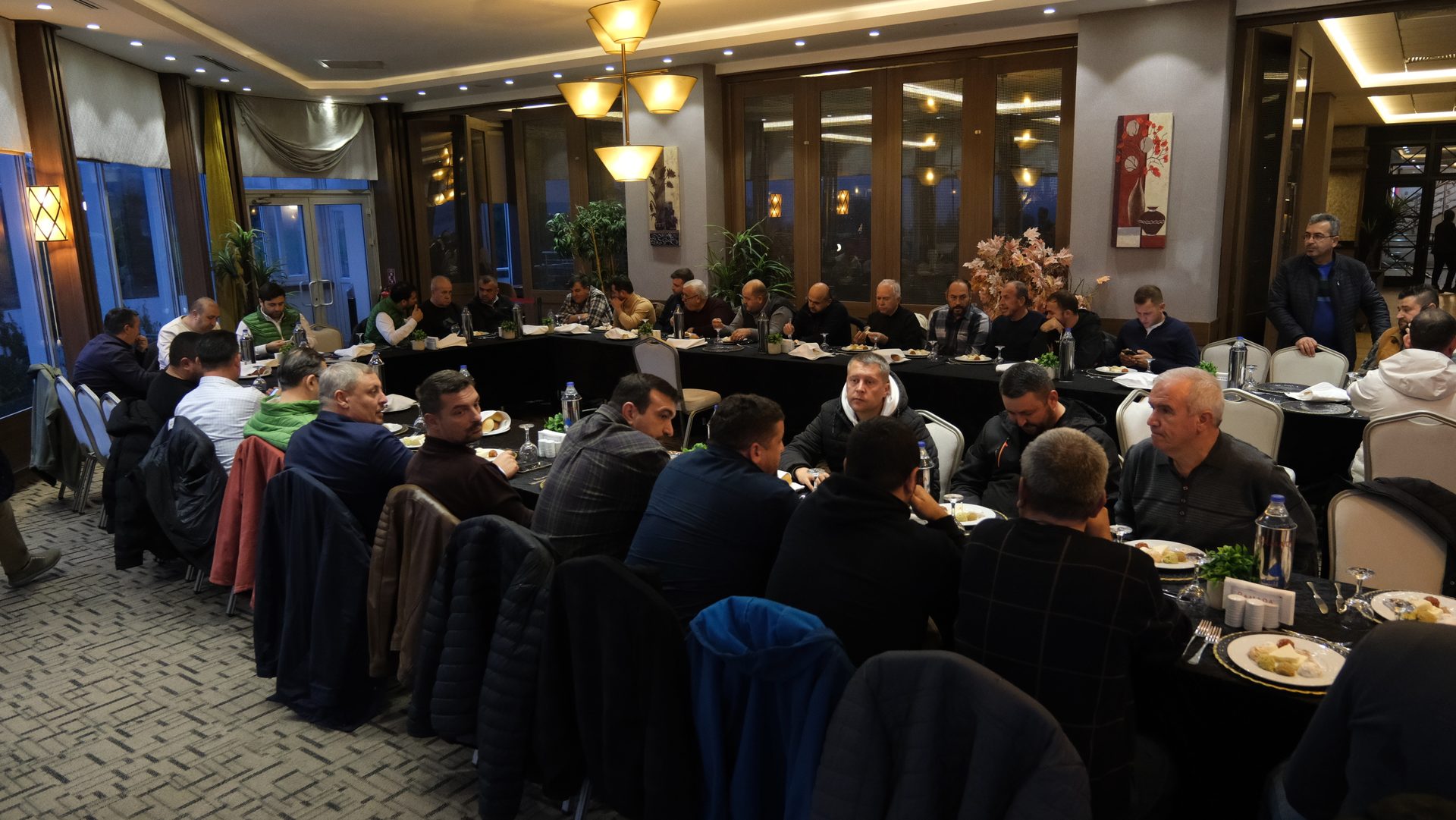 Interior design, Furniture, Chair, Crowd, Event, Suit, Table, Coat, Interaction, Meeting