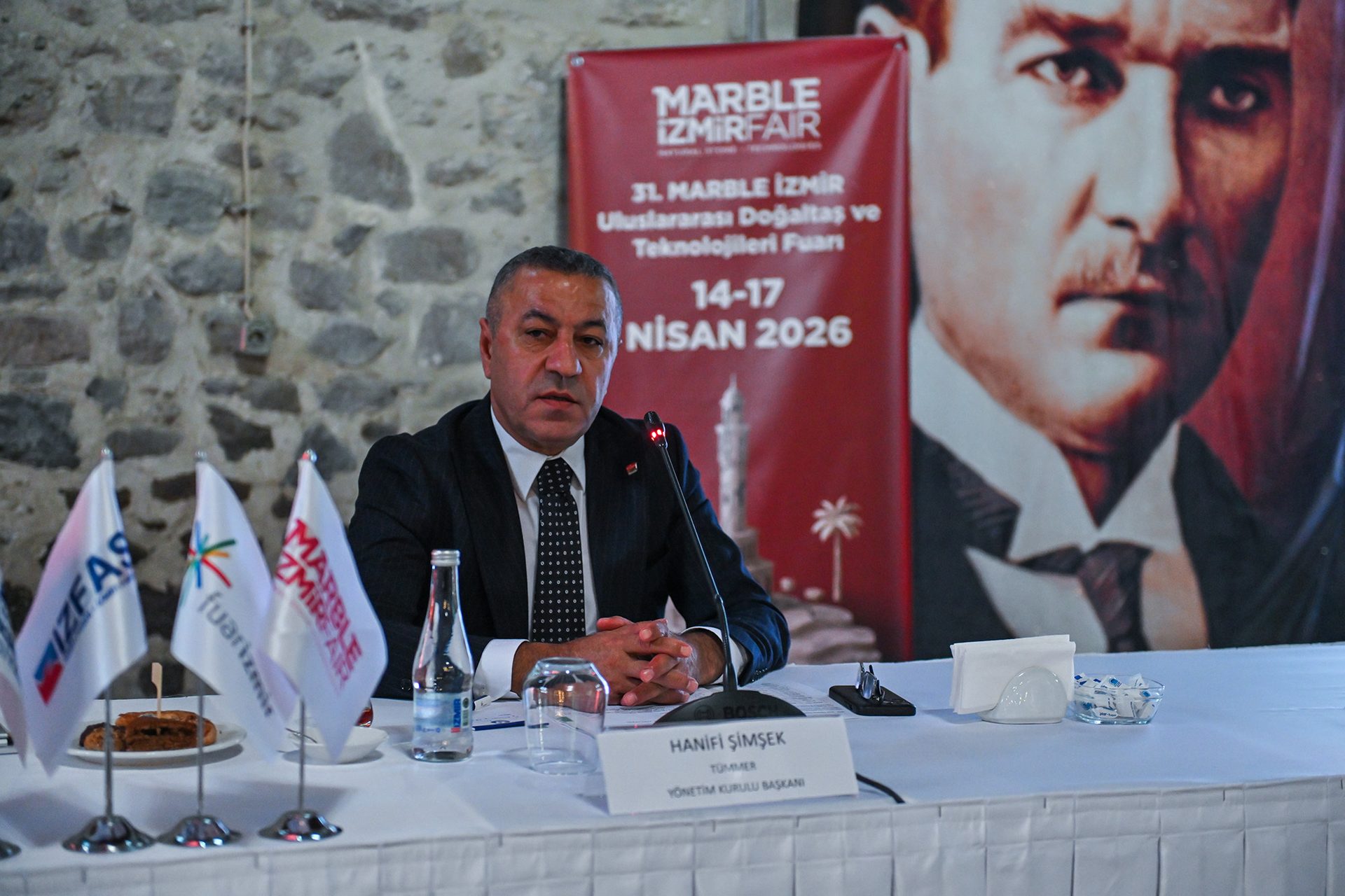 Hanifi Şimşek, Yönetim Kurulu Başkanı, at the Marble İzmir Fair with Atatürk's image in the background.