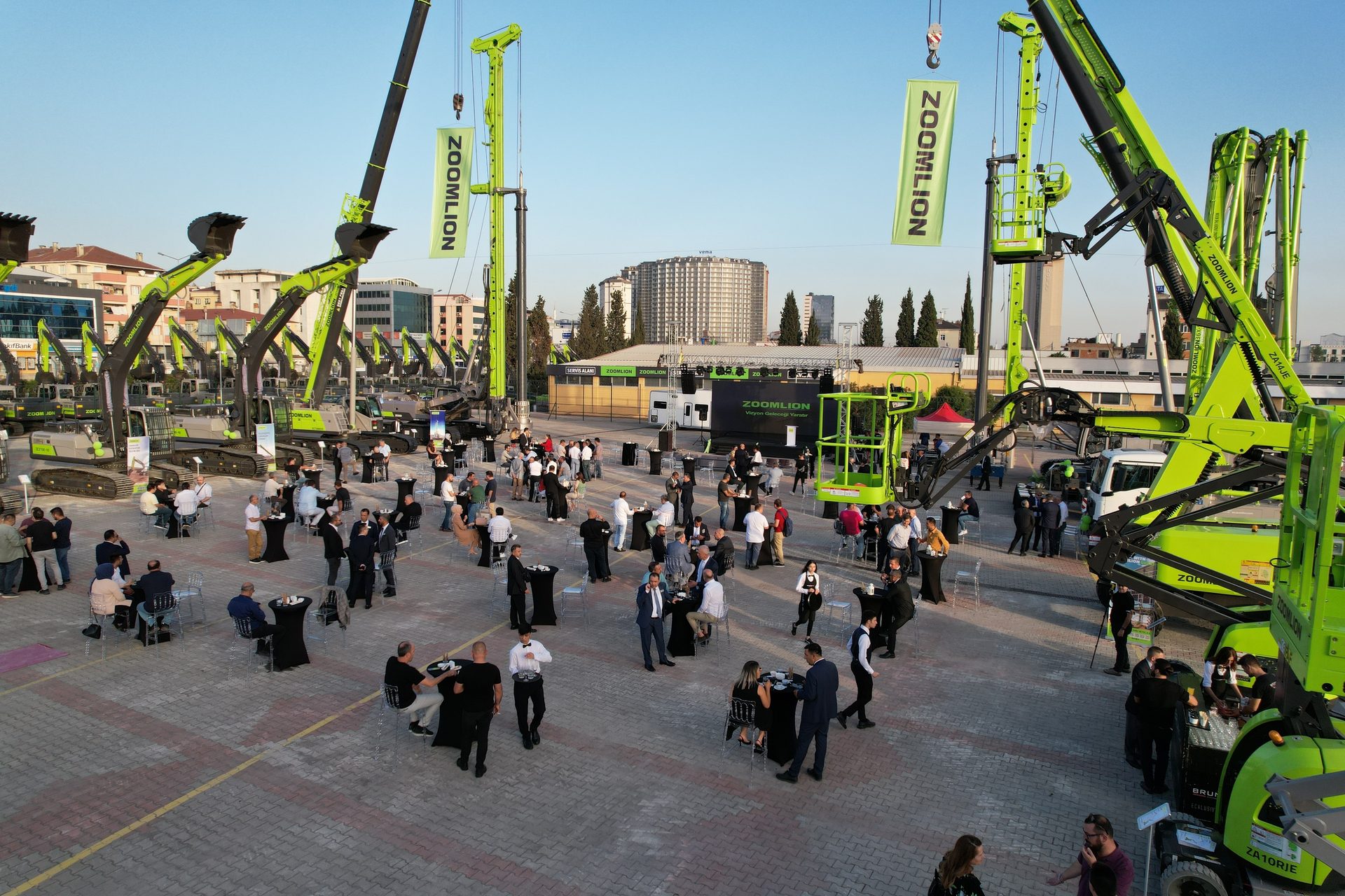 Outdoor ZOOMLION event with heavy machinery display and people socializing.