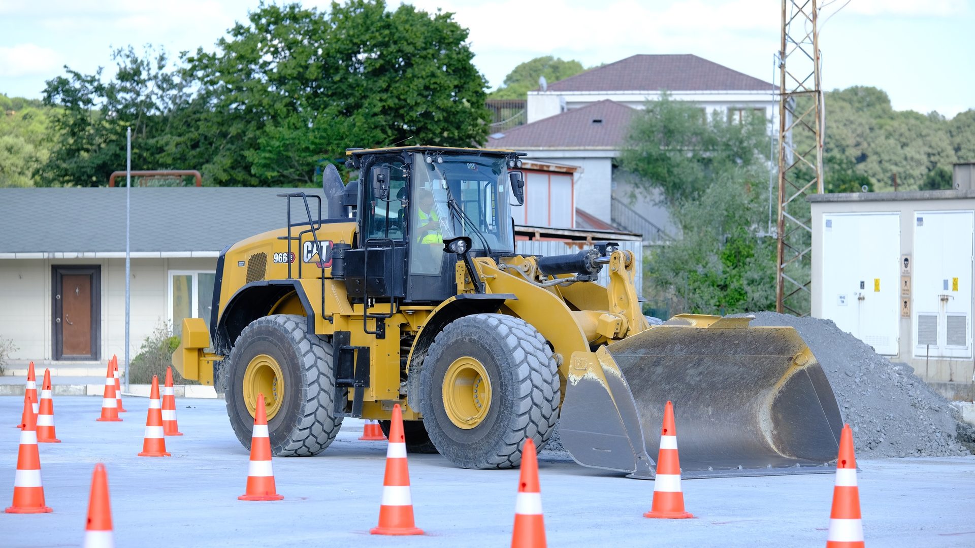 Yellow CAT front-end loader surrounded by orange cones.
