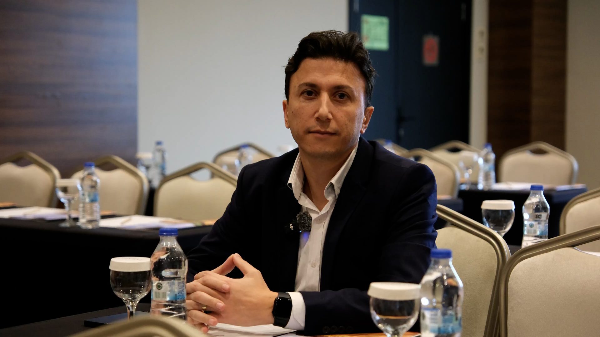 White-collar worker, Electronic device, Formal wear, Furniture, Table, Drinkware, Suit, Coat, Chair, Microphone