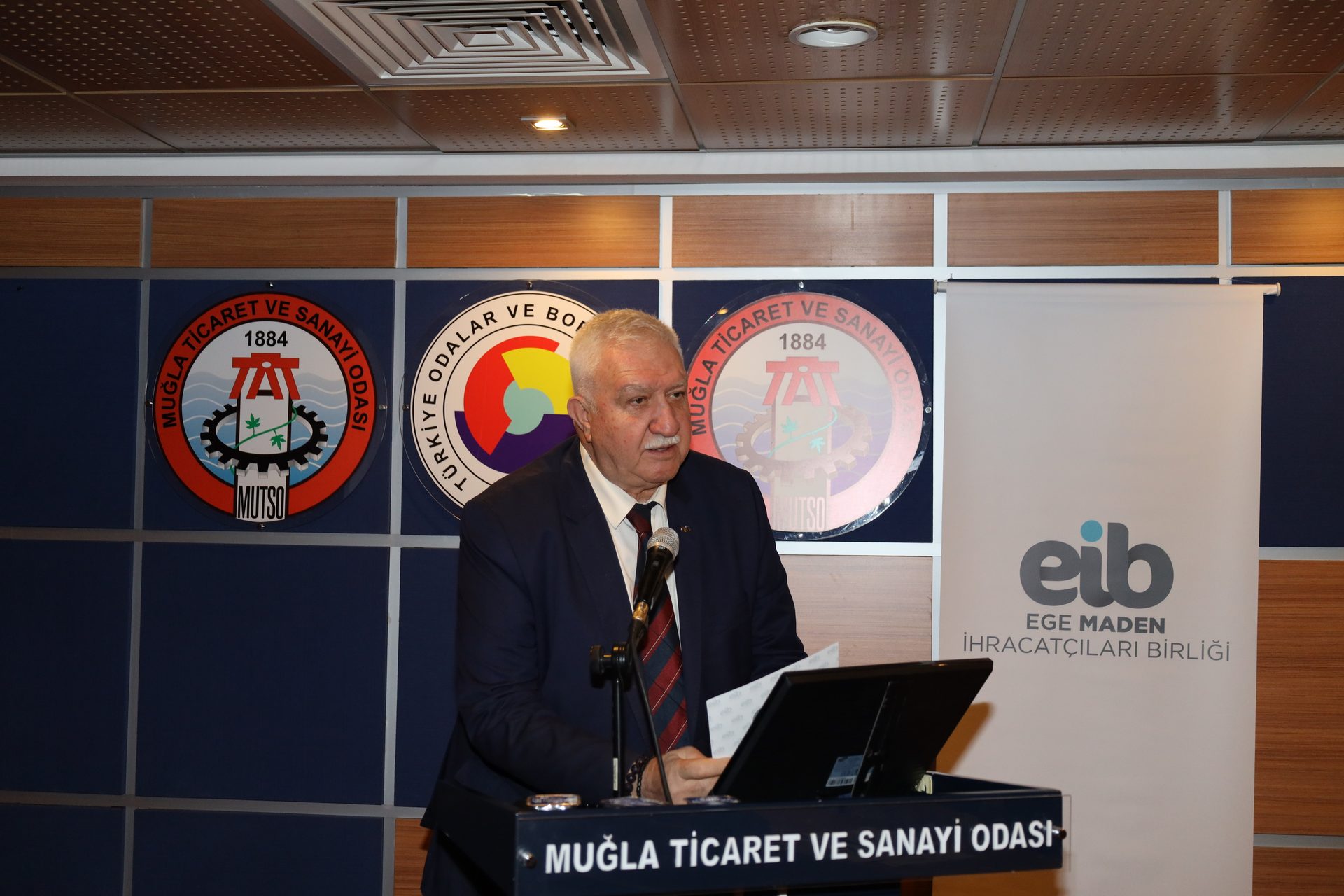 White-collar worker, Electronic device, Suit, Outerwear, Furniture, Coat, Necktie, Blazer, Logo, Chair