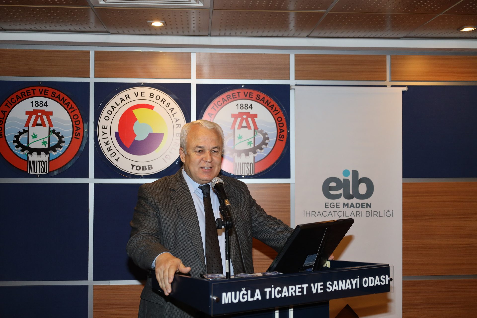 White-collar worker, Electronic device, Outerwear, Suit, Furniture, Coat, Necktie, Blazer, Chair, Logo