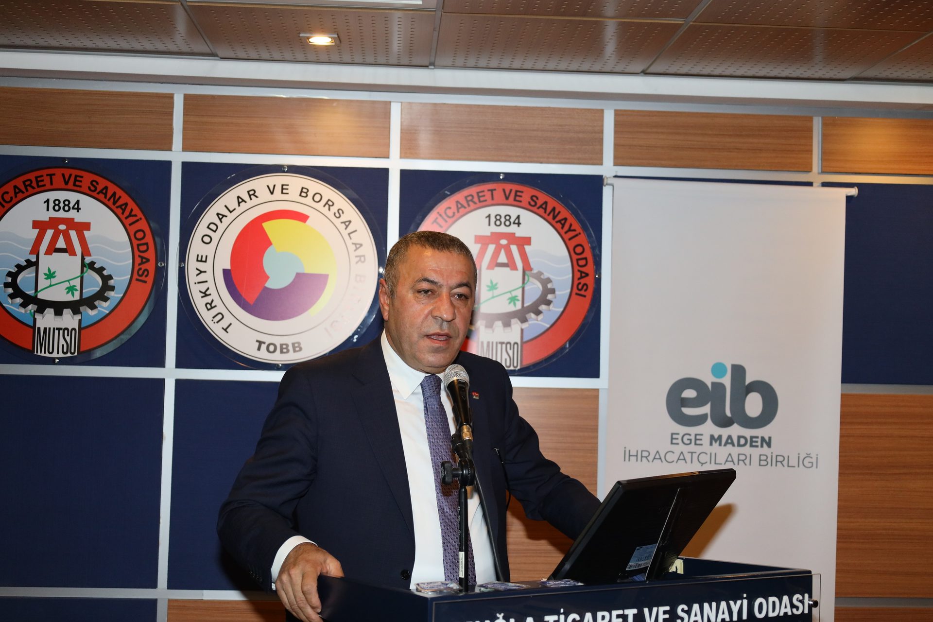 White-collar worker, Electronic device, Outerwear, Suit, Furniture, Coat, Necktie, Blazer, Job, Logo