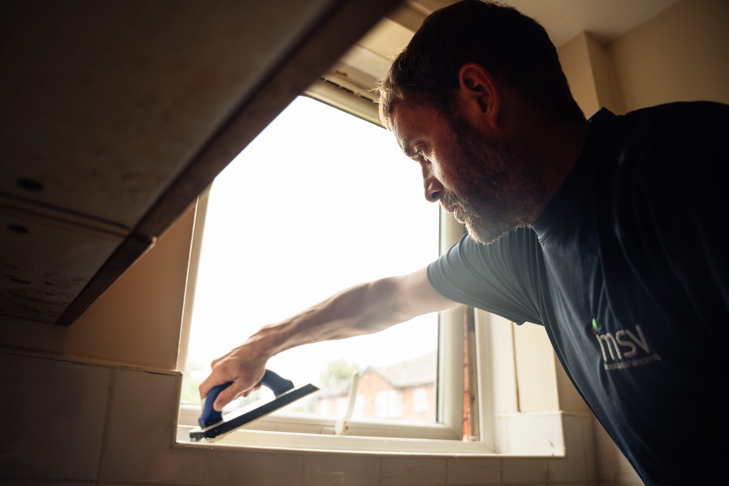 MSV staff member grouting a window ledge