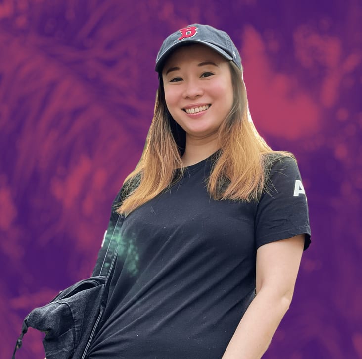 Flash photography, Baseball cap, Smile, Hairstyle, Purple, Sleeve, Gesture, T-shirt, Waist