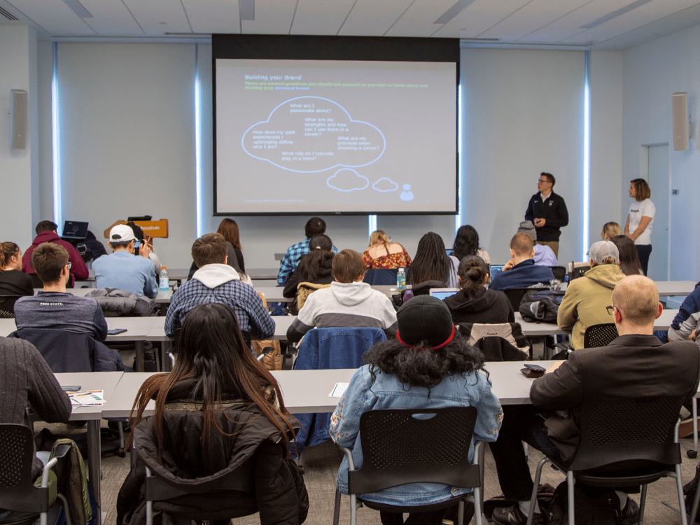 Students attend a presentation on "Building your Brand" in a lecture hall.