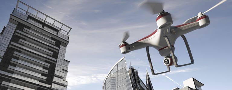 Drone flying near modern city buildings.