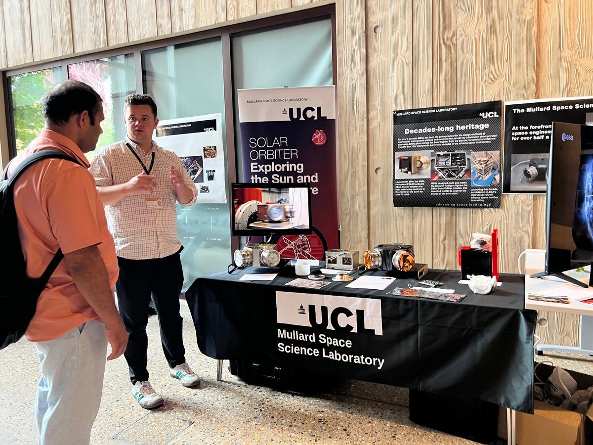 Two men at a UCL space science exhibit with instruments.