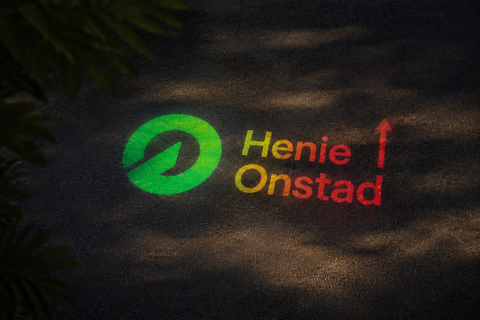 Henie Onstad Art Centre logo and name projected onto asphalt, with leaves in the foreground.