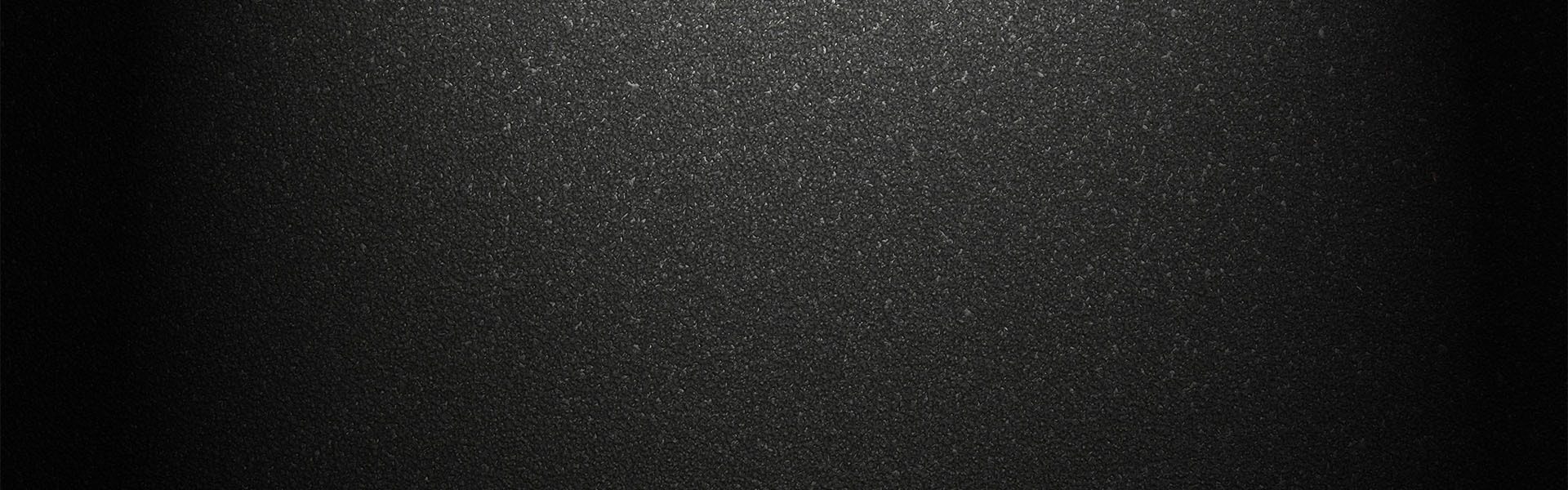 A dark, textured background with a subtle grain or speckle effect, featuring a central highlight.