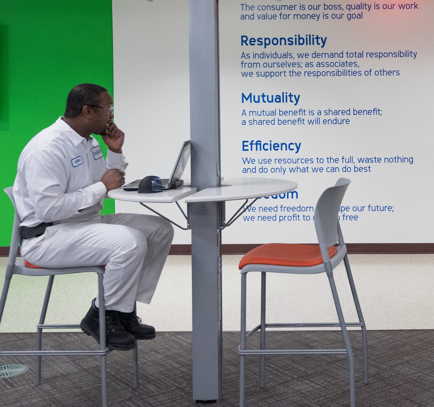 worker using a laptop in the breakroom of a facility