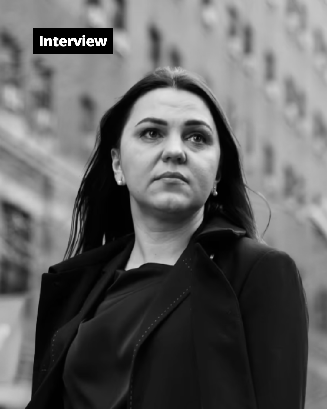 A black and white portrait of a woman with long hair, looking intently towards the upper right.