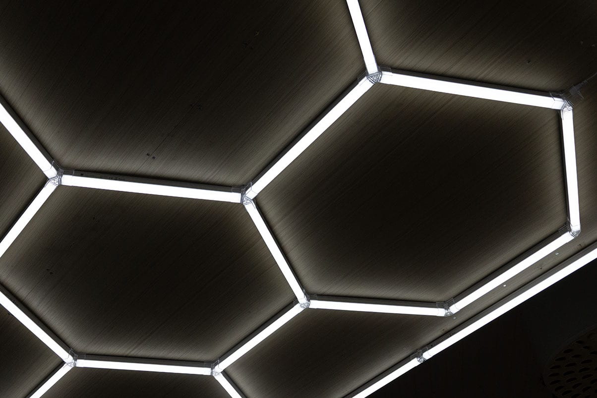Illuminated hexagonal pattern on a dark ceiling.