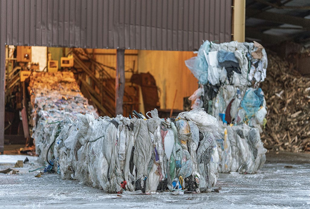 Bales of compressed plastic waste in a recycling facility.