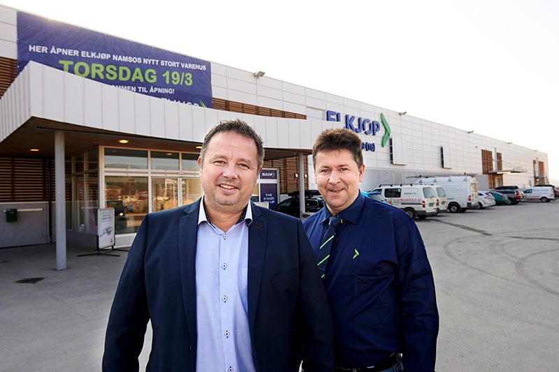 Two men smiling in front of an Elkjop store opening in Namsos on Thursday 19/3.