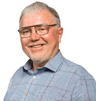 Smiling man with glasses, gray hair, and beard.