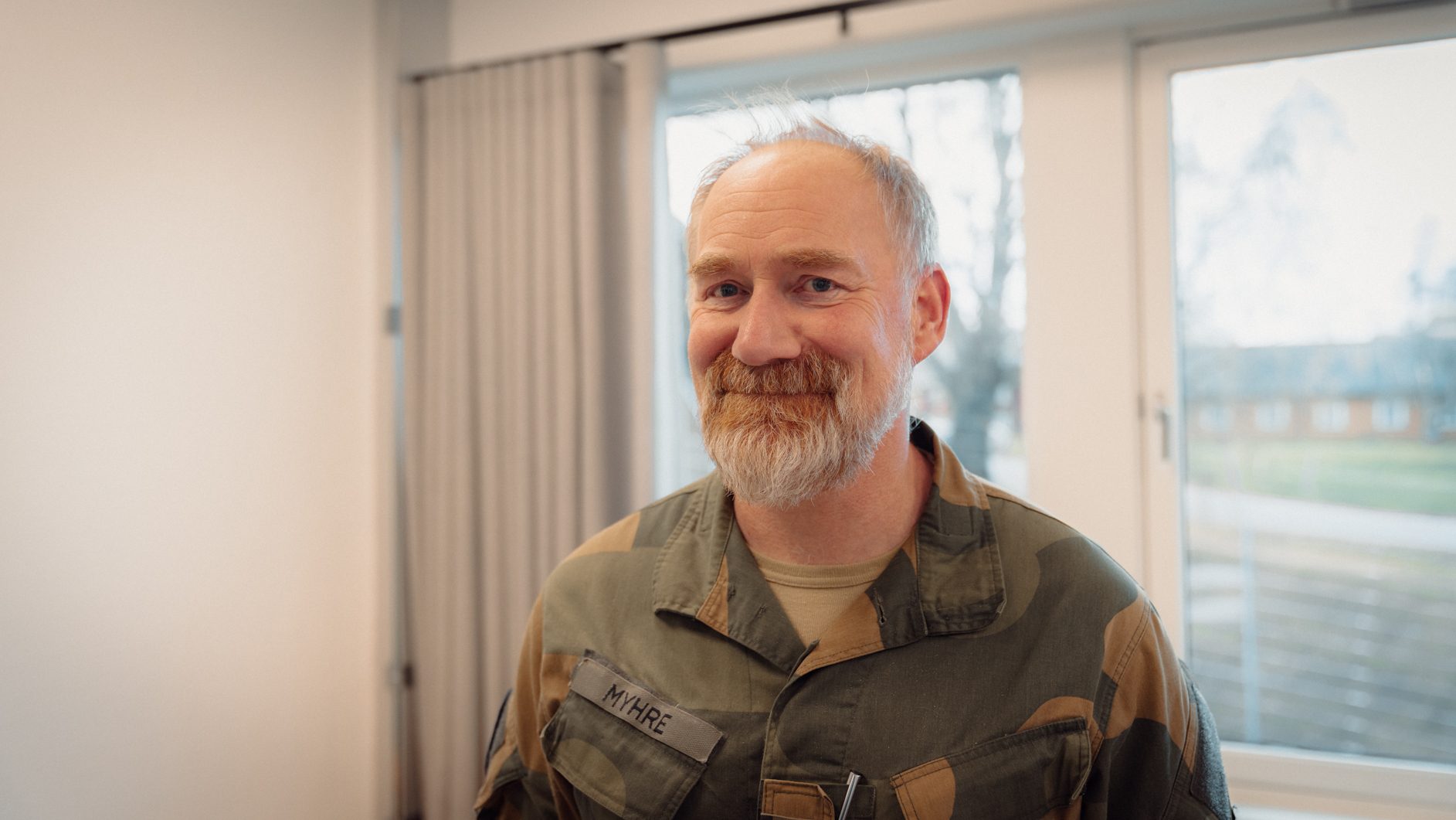Smiling man with beard in military uniform, name tag 'MYHRE'.