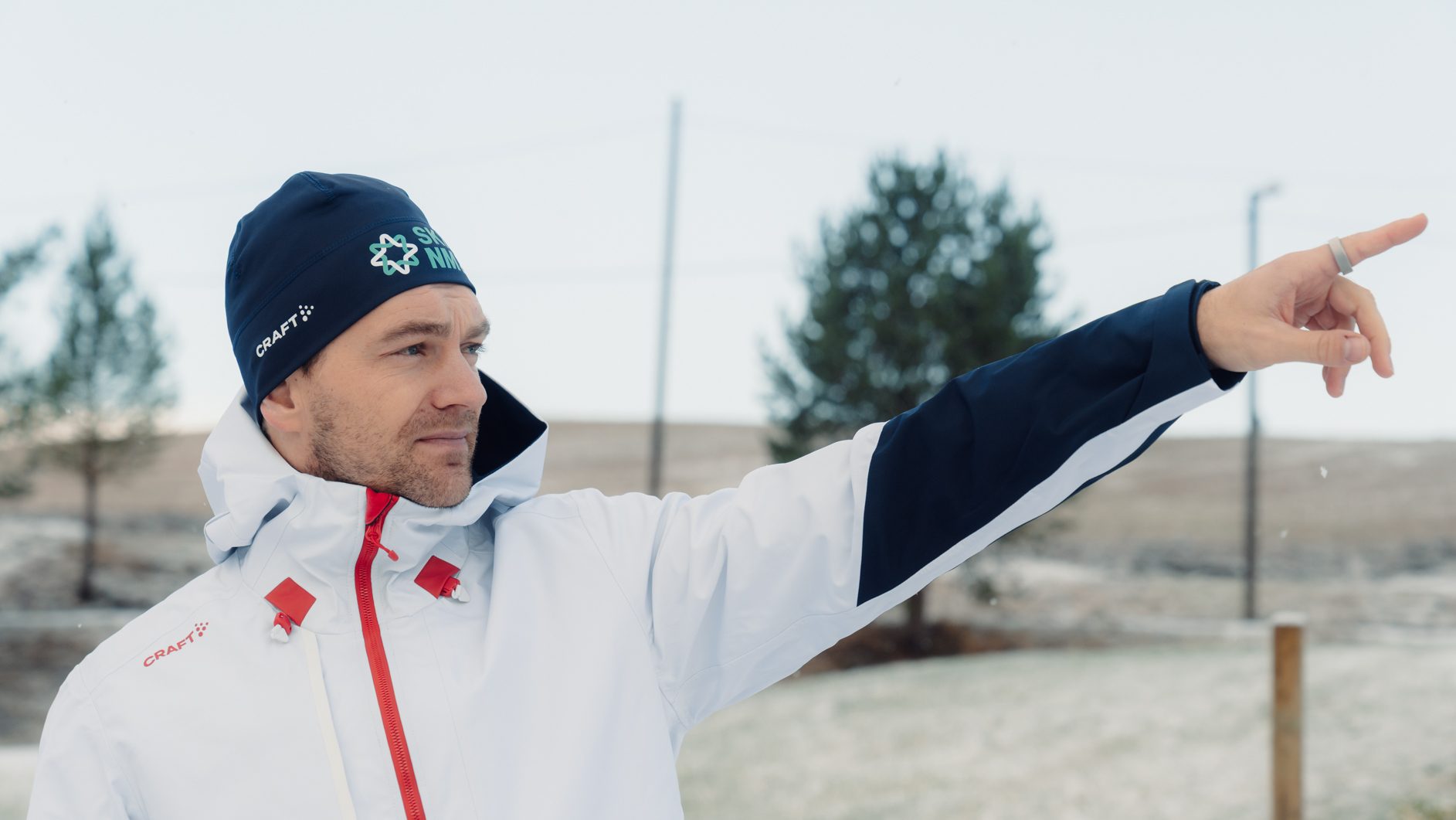 Man in Craft jacket and beanie pointing, Craft logos visible.