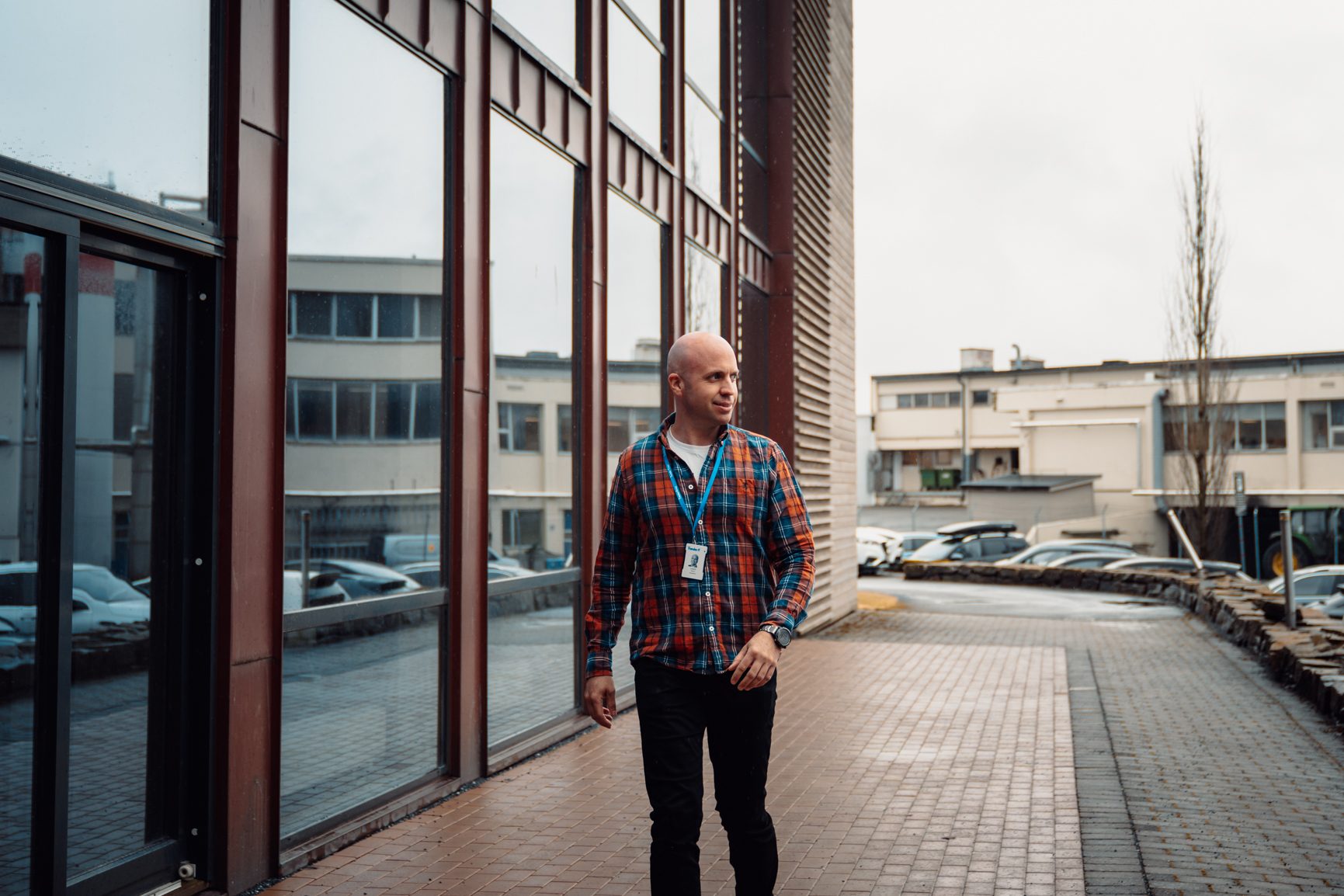 Dress shirt, Road surface, Building, Sky, Sleeve, Standing, Architecture, Line, Wheel, Tartan