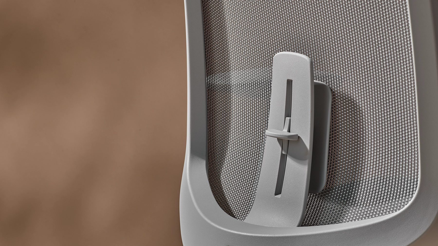 Grey mesh office chair back with adjustable lumbar support.