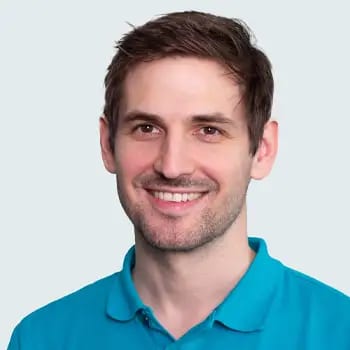 Smiling man with short brown hair and light stubble.