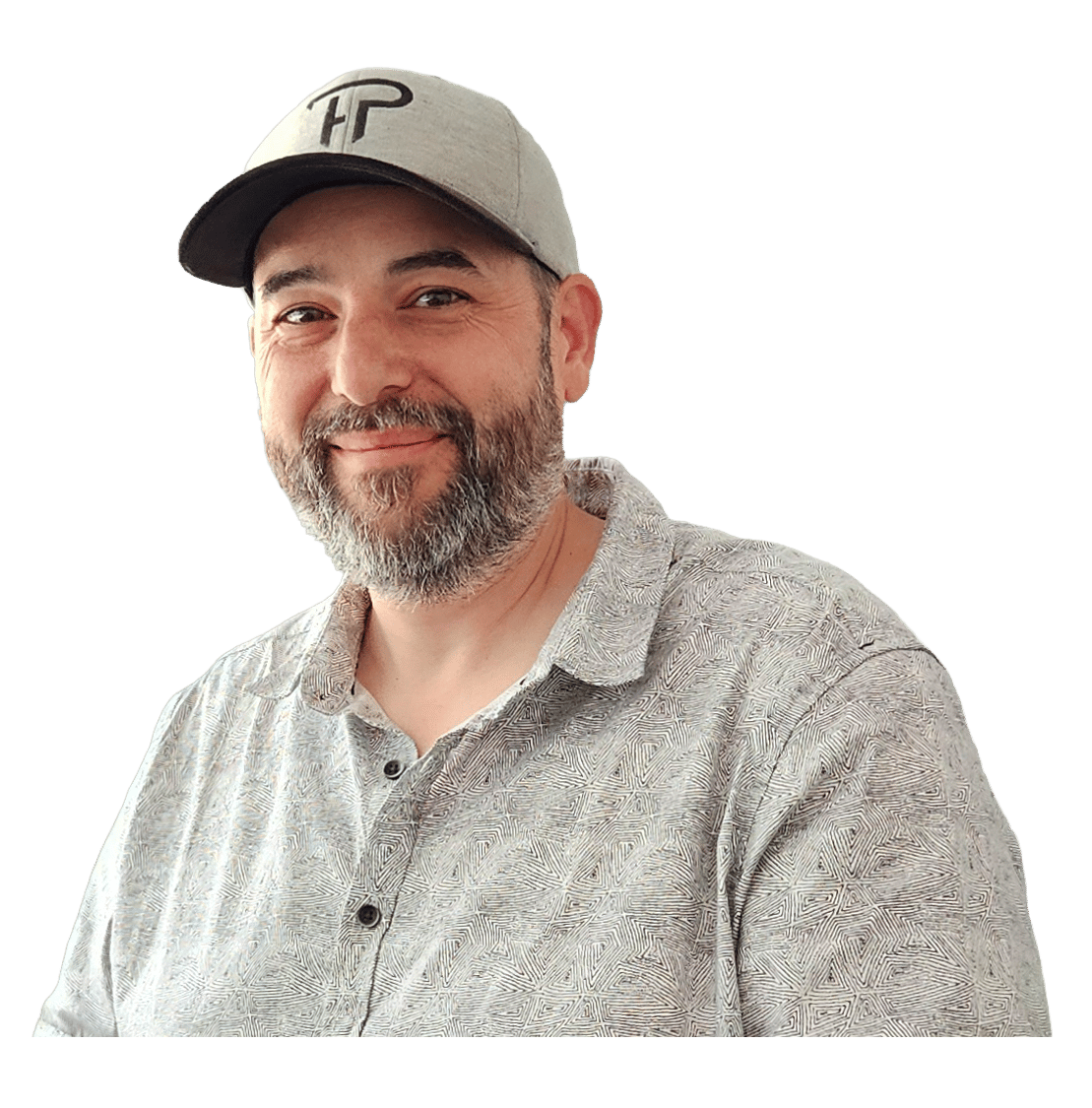 A smiling man with a beard and a grey baseball cap, wearing a patterned collared shirt.
