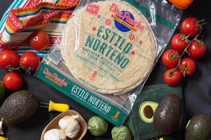 Don Pancho flour tortillas surrounded by fresh ingredients like tomatoes, avocados, garlic, and tomatillos.