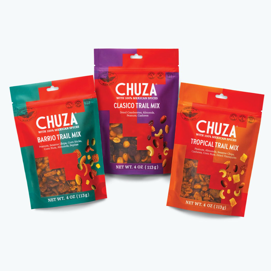 Three colorful Chuza trail mix bags: green Barrio, purple Clasico, and orange Tropical flavors.
