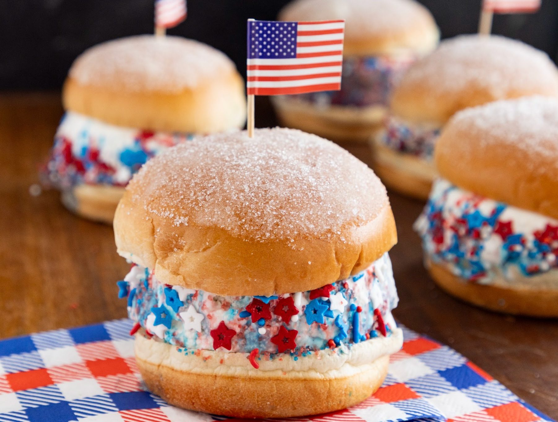 Sugared ice cream sandwiches with red, white, blue sprinkles and stars, one with an American flag.