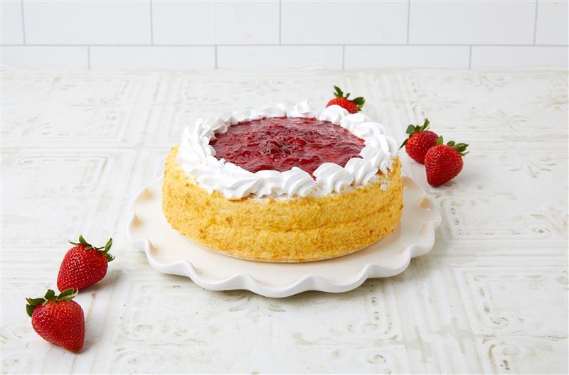 Plated cake with whipped cream and strawberries