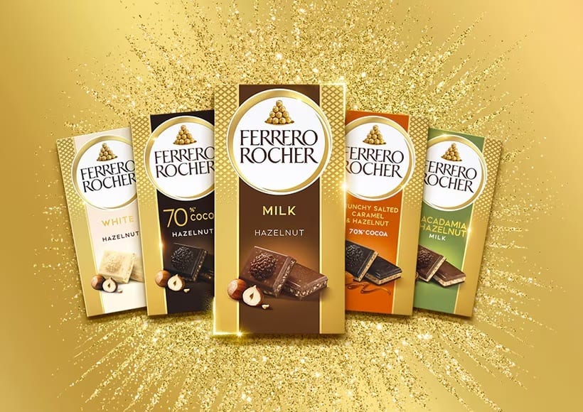 Five Ferrero Rocher chocolate bars, various flavors, arranged on a sparkling gold background.