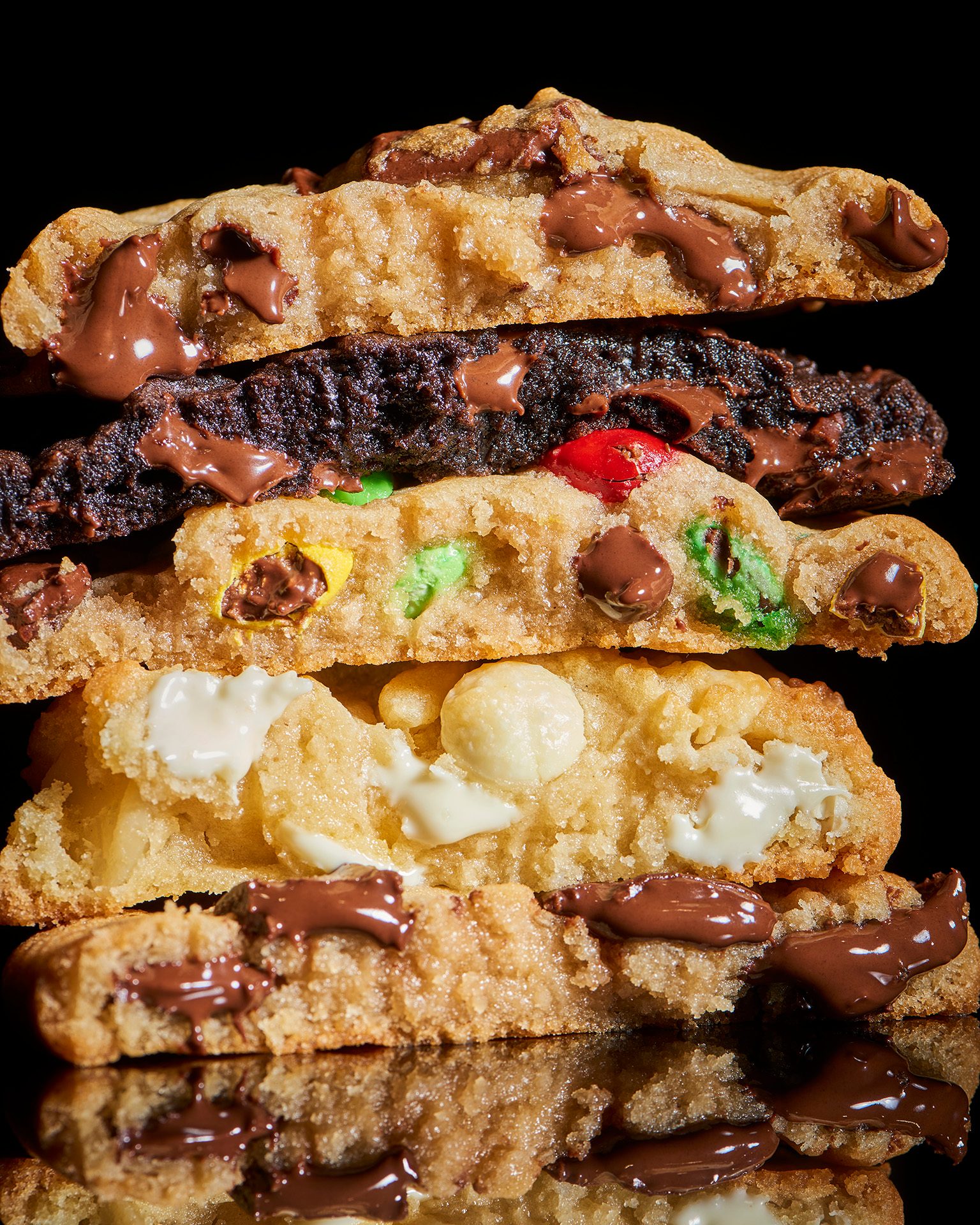 Stacked cookies, split to reveal gooey chocolate, M&Ms, and white chocolate fillings.