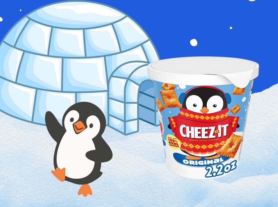 Waving cartoon penguin, igloo, and a penguin-themed Cheez-It snack cup on snow.
