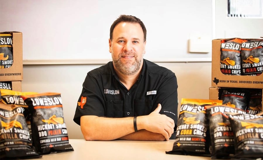 Man with beard surrounded by Loweslow brand hickory smoked chips.