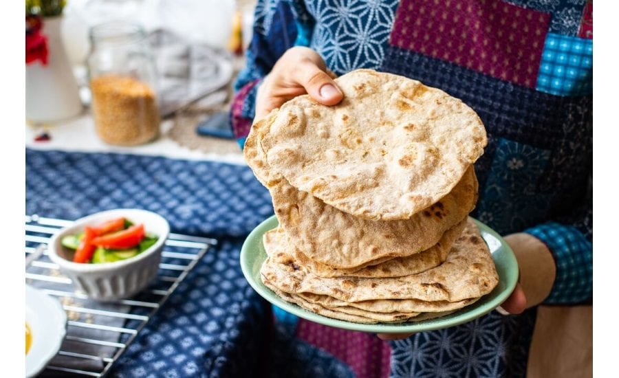 Person holding plate, Hand, Sweater, Flatbreads, Kitchen counter