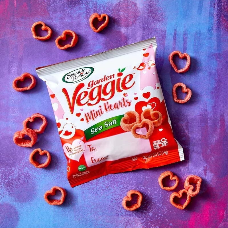 Bag of heart-shaped Sensible Portions Garden Veggie Mini Hearts snacks on a purple background.
