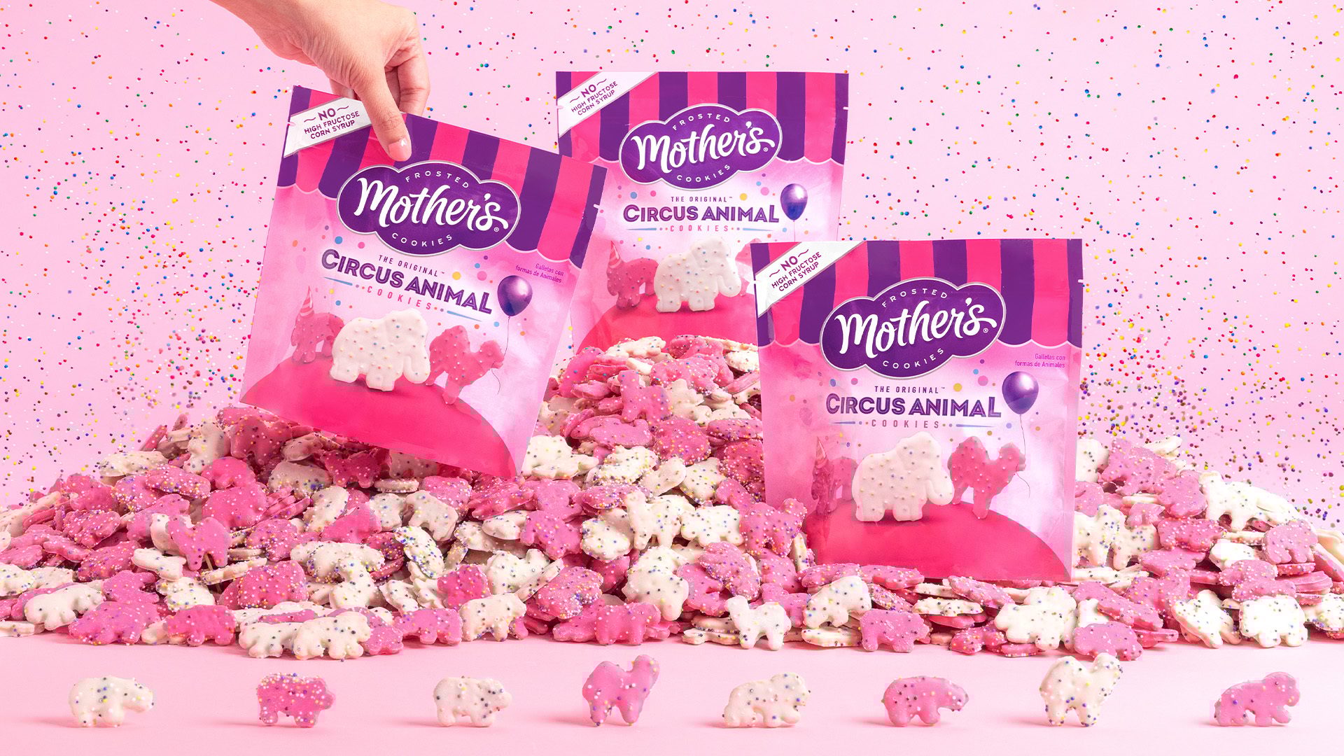 Mother’s Cookies Circus Animal Cookies in bags on top of the cookies in a pile and lined up, with a pink background.