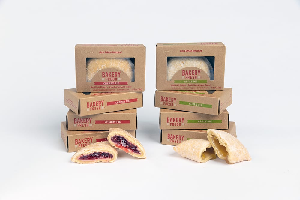 Two stacks of Bakery Fresh pies (cherry and apple), with some pies cut open to reveal fruit filling.