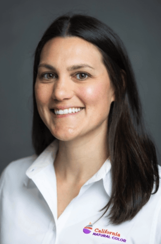 Smiling woman in white shirt with California Natural Color logo.