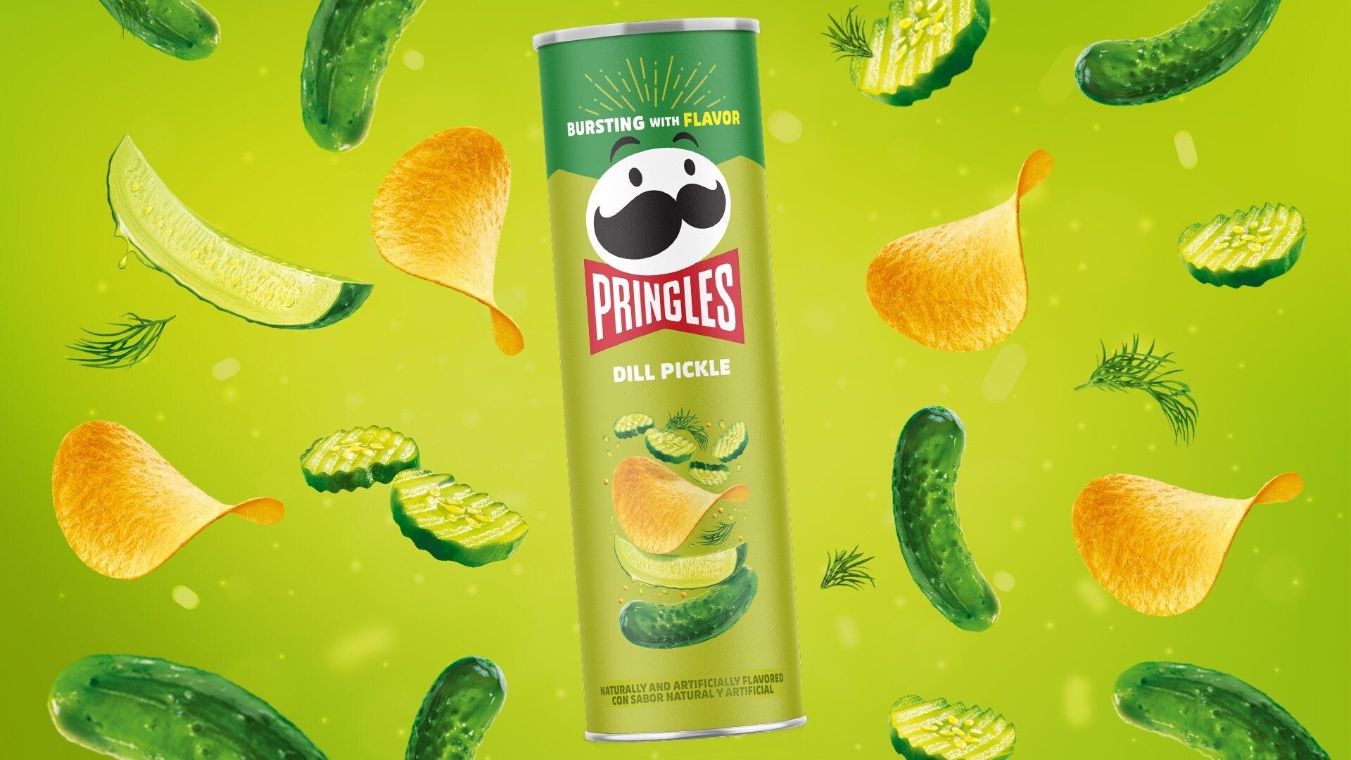 Pringles Dill Pickle can with chips, pickles, and dill on a green background.