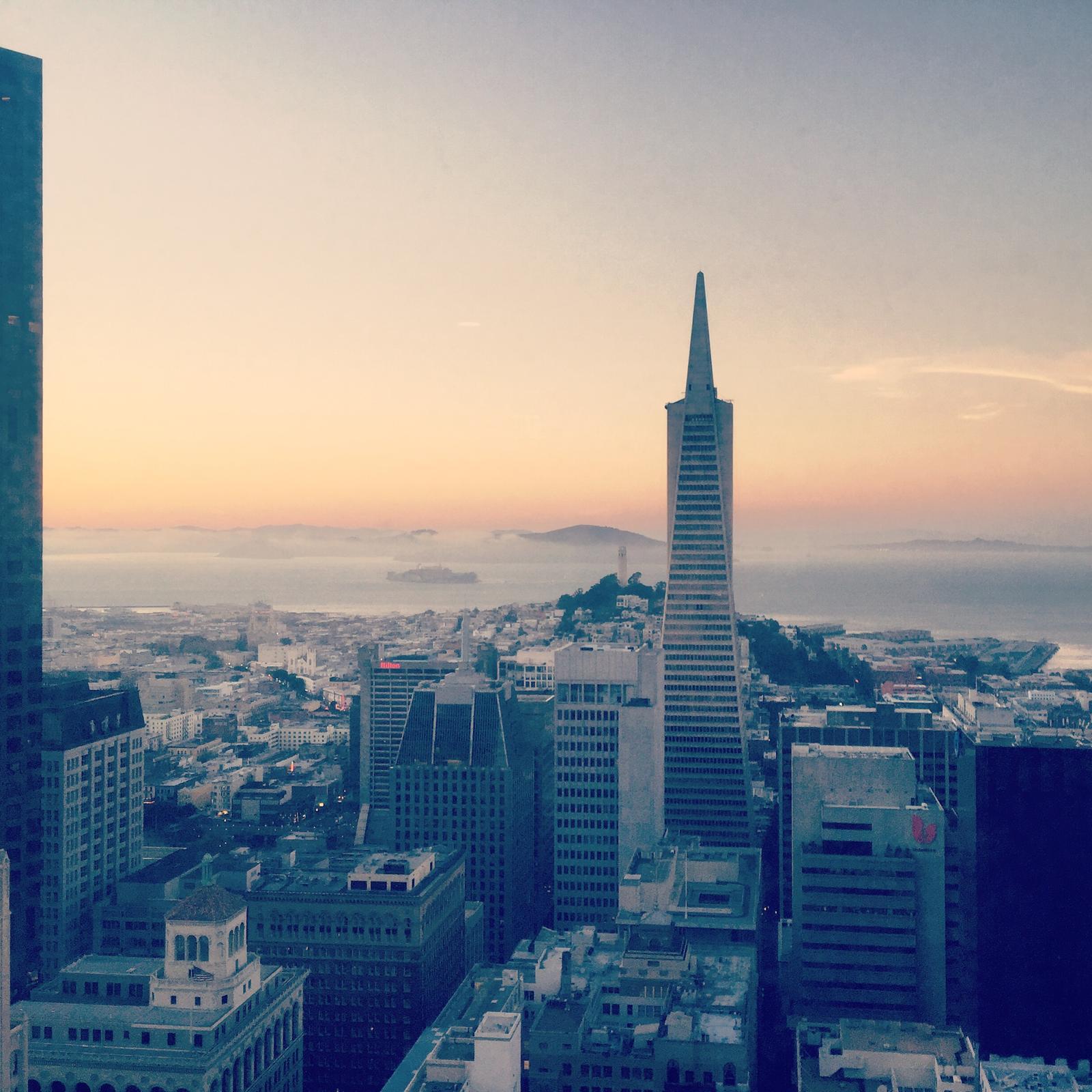 San Francisco cityscape at sunset with Transamerica Pyramid and bay.