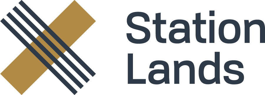 Logo for Station Lands, featuring an abstract gold and blue 'X' shape with parallel lines next to the company name.