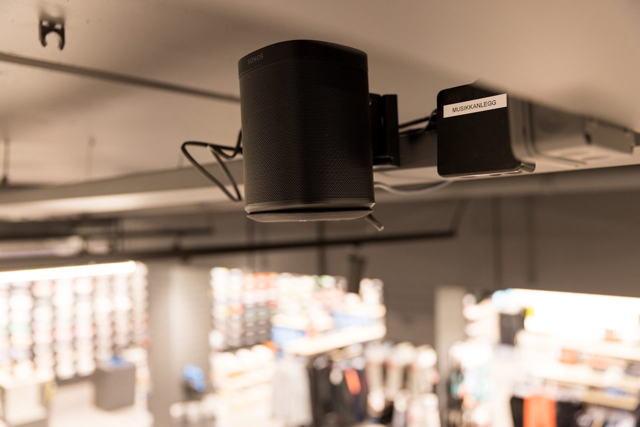 En sort h&#xF8;yttaler i taket i et butikklokale.
