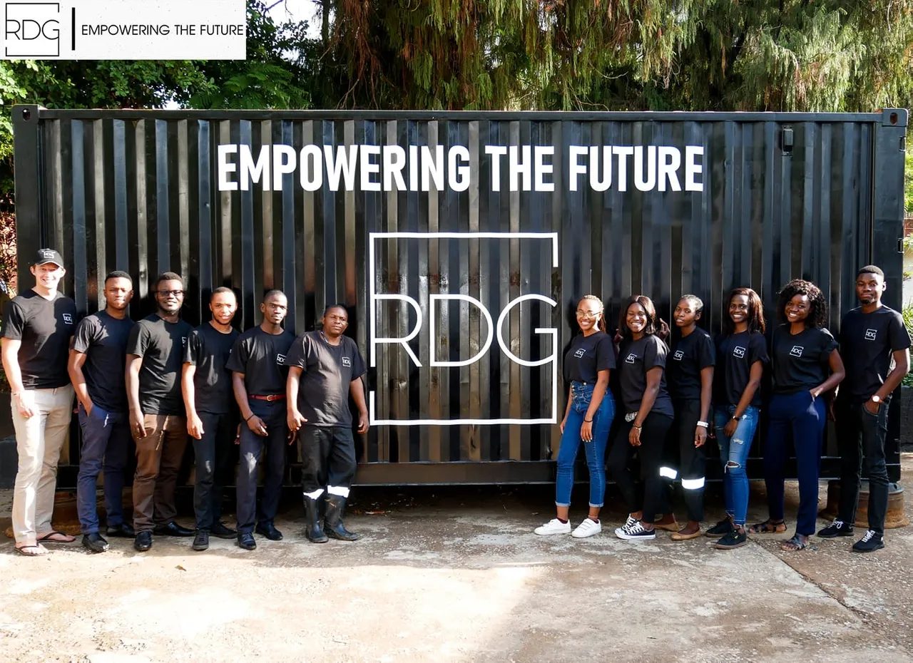 Team photo in front of container with 'RDG Empowering the Future' text.