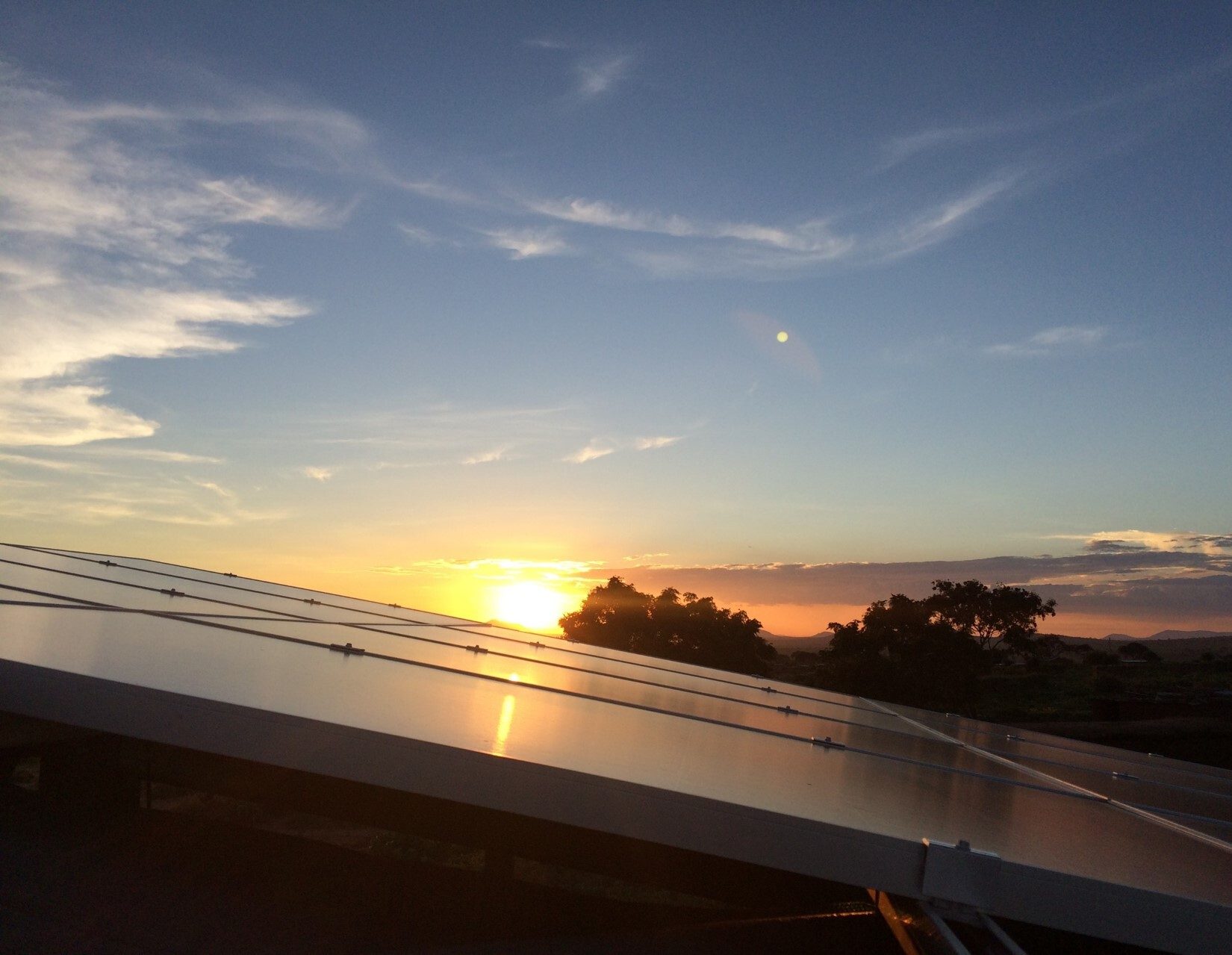 Solar panels reflecting sunset sky.